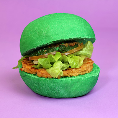 Bun verde alla spirulina, Burger non è pollo, cipolle croccanti, gentilina, pomodoro, salsa spinaci e noci 